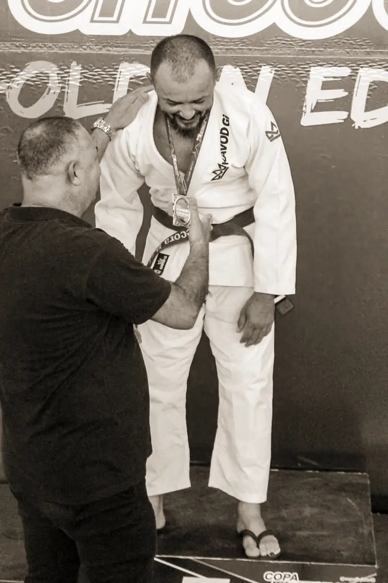 Pécora de kimono branco recebendo a medalha na premiação